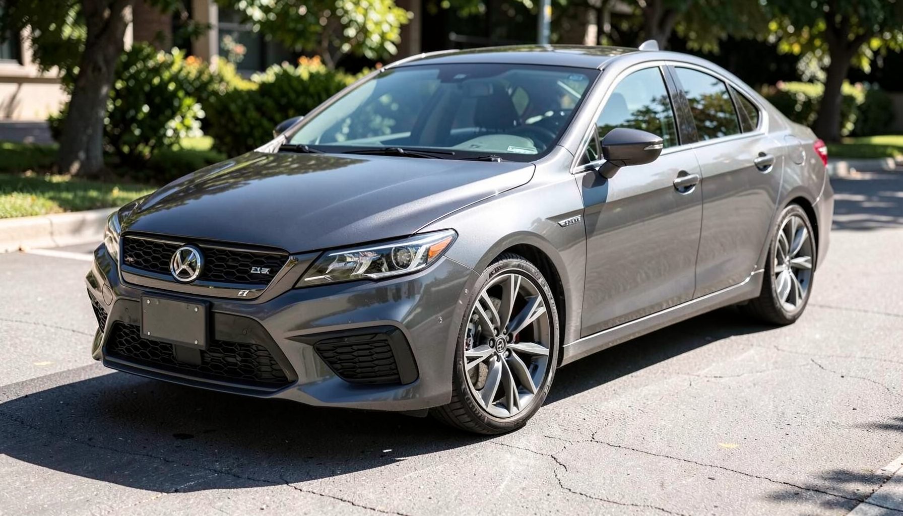 A sporty dark gray sedan with alloy wheels and a bold front fascia, parked at an angle on sunlit pavement.